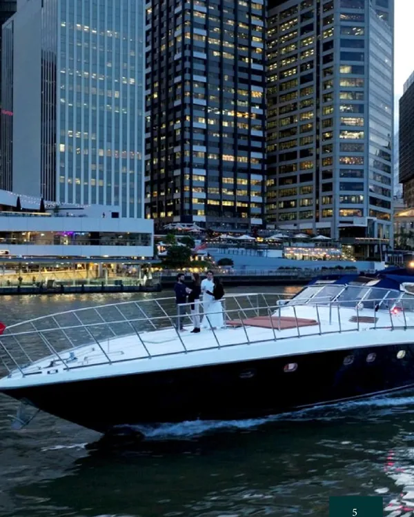 Bote on the Brisbane River at dusk beneath the city towers