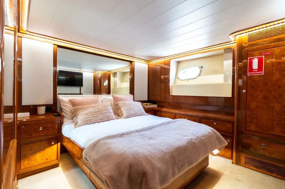 Master cabin on Bote with a double bed and burl timber joinery
