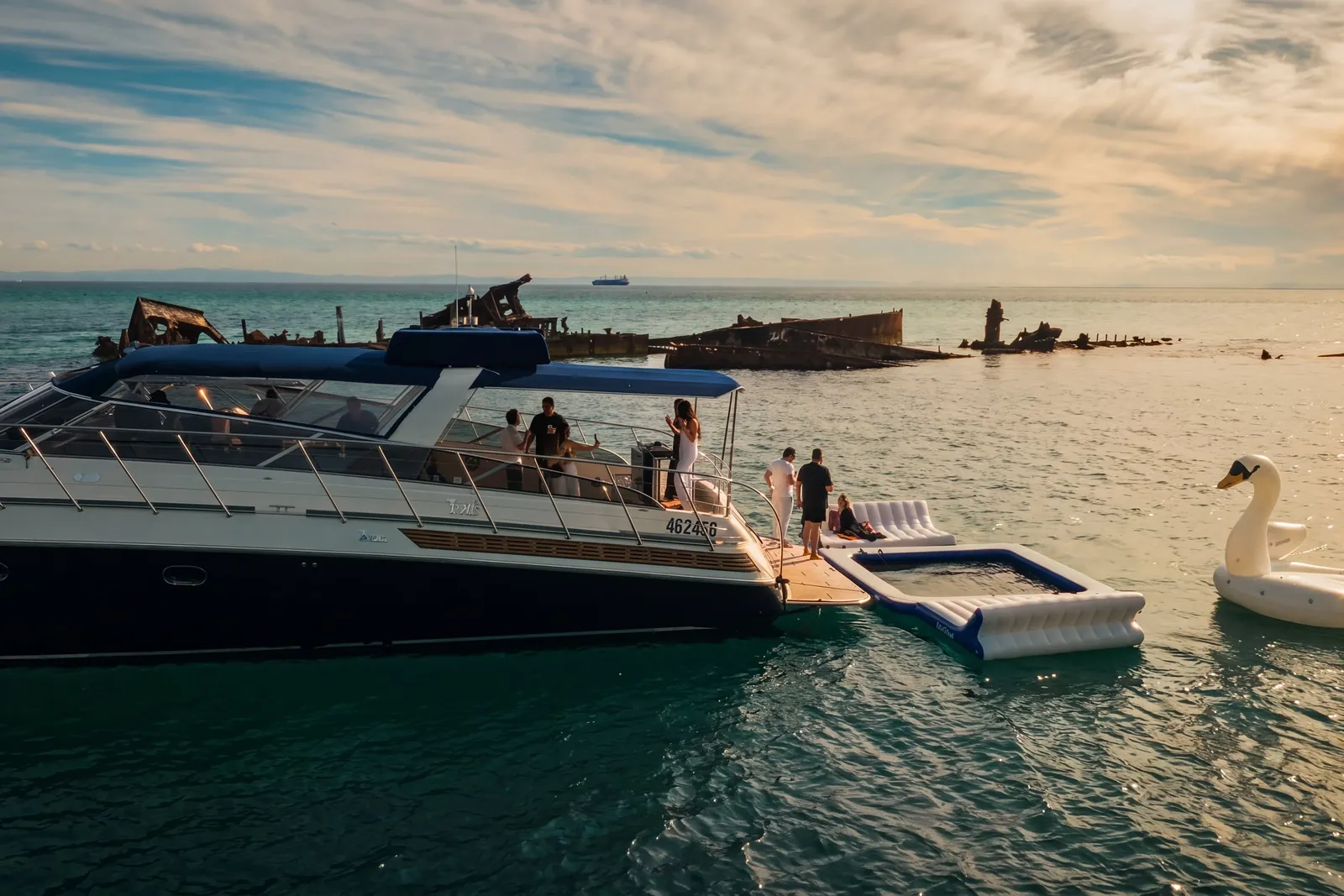 Guests on the aft deck of Bote at anchor with inflatables off the Tangalooma wrecks