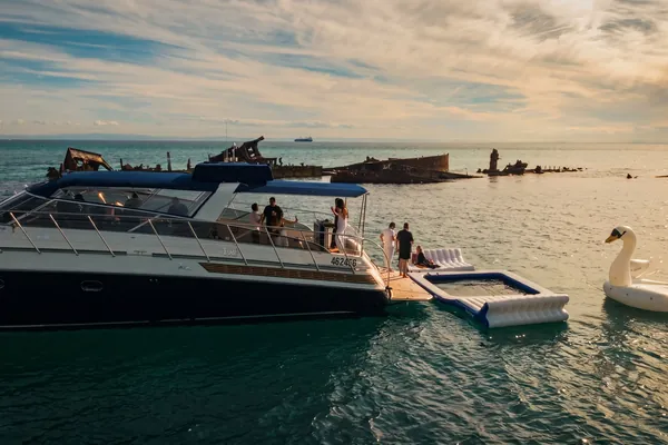 Guests on the aft deck of Bote with inflatables at anchor off the Tangalooma wrecks