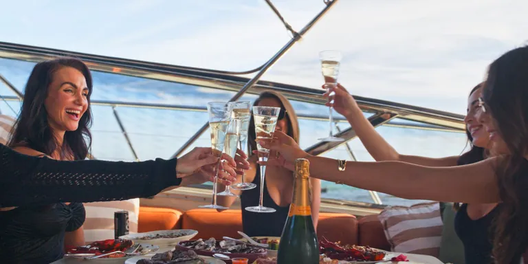 Guests toasting over platters on the aft deck of Bote
